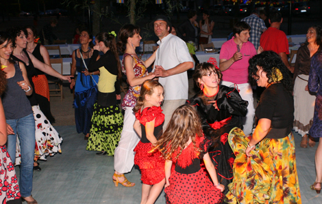 Cette photo représente une fête regroupant des enfants ainsi que des adultes qui dansent habillés aux couleurs de l'Espagne