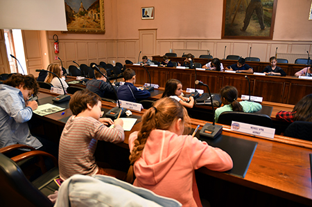 Cette photo représente une séance du conseil des enfants assis dans la salle du conseil municipal de la mairie de marmande