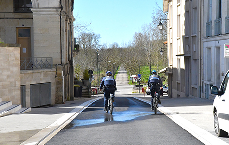 Cette photo réprésente deux membres de la police de Marmande de dos à vélo dans une rue de Marmande